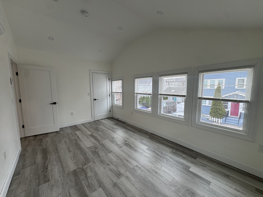 16 Adams Street, Unit 1 Boston, MA 02136 - Photo 14 of 15 an empty room with wooden floor and windows