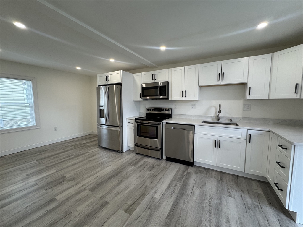 16 Adams Street, Unit 1 Boston, MA 02136 - Photo 3 of 15 a kitchen with granite countertop a stove top oven a sink dishwasher and a refrigerator with wooden floor