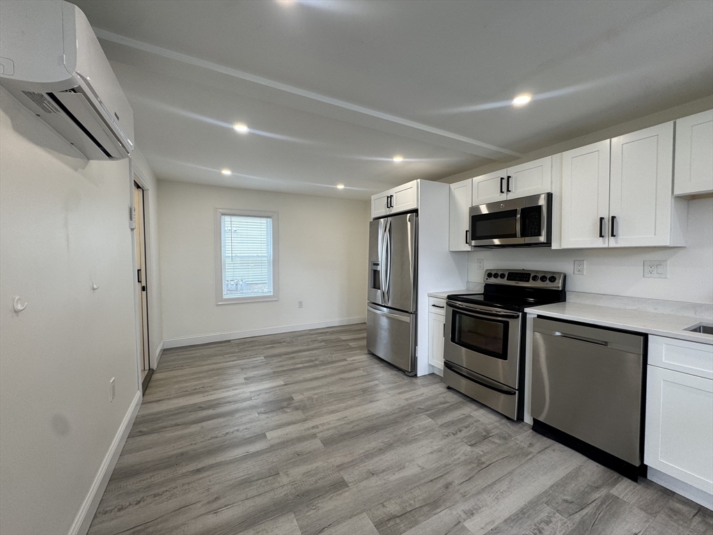 16 Adams Street, Unit 1 Boston, MA 02136 - Photo 4 of 15 a kitchen with granite countertop a refrigerator and a stove top oven