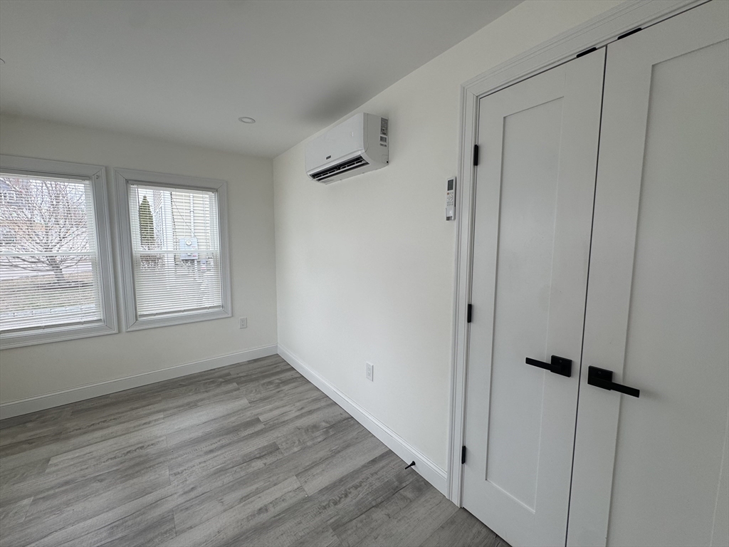 16 Adams Street, Unit 1 Boston, MA 02136 - Photo 7 of 15 a view of an empty room with wooden floor and a window