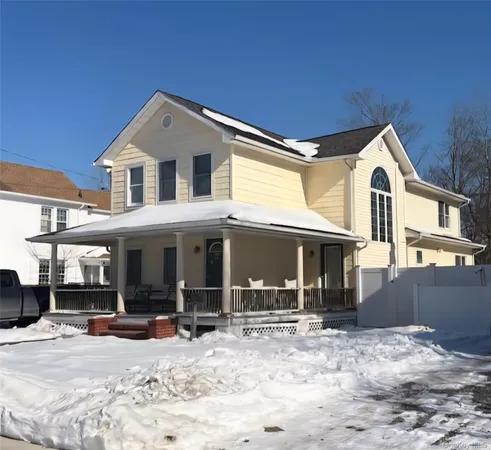 a front view of a house with a yard covered in snow