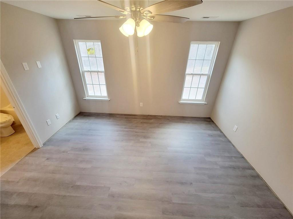 1049 East Hanover Road Graham, NC 27253 - Photo 8 of 14 an empty room with windows and chandelier fan