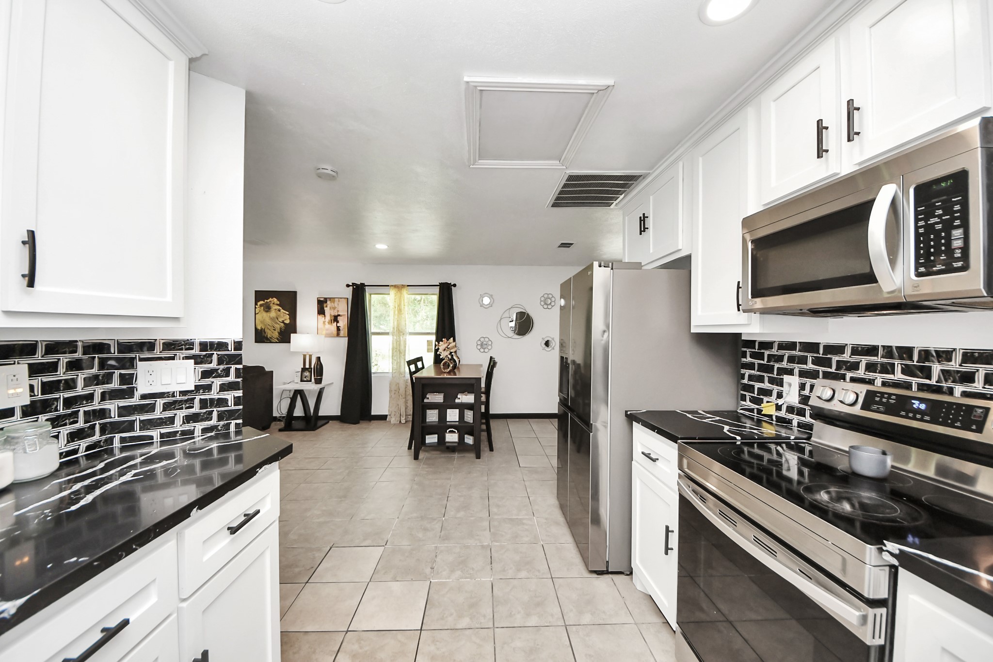 238 Waterfall Drive Huffman, TX 77336 - Photo 18 of 40 a kitchen with stainless steel appliances a stove a sink and a microwave