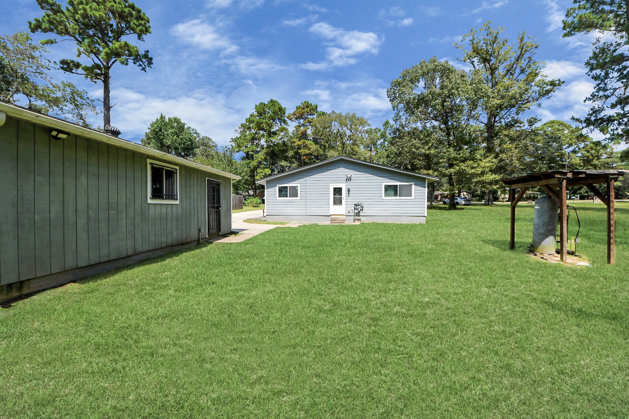238 Waterfall Drive Huffman, TX 77336 - Photo 10 of 40 a white house with a small yard and large trees