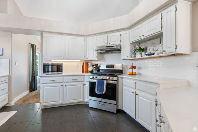 790 East Fiddlers Canyon Road Cedar City, UT 84721 - Photo 12 of 35 Kitchen featuring white shaker-style cabinetry, white subway tile backsplash, stainless steel range with overhead microwave, white countertops, and dark tile flooring
