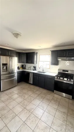 a kitchen with stainless steel appliances kitchen island granite countertop a sink dishwasher stove top oven and cabinets
