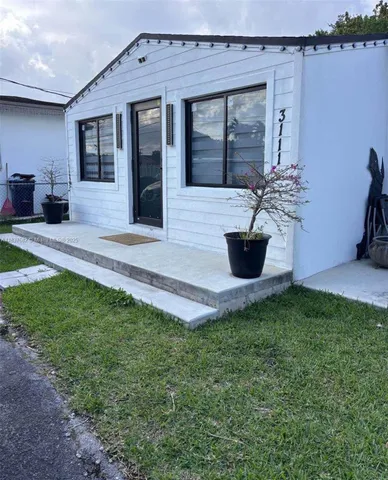 a view of a house with backyard and sitting area