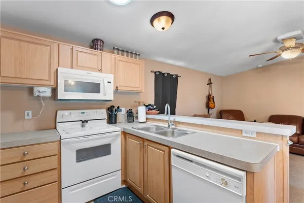 a kitchen with granite countertop a sink dishwasher a stove and cabinets with wooden floor