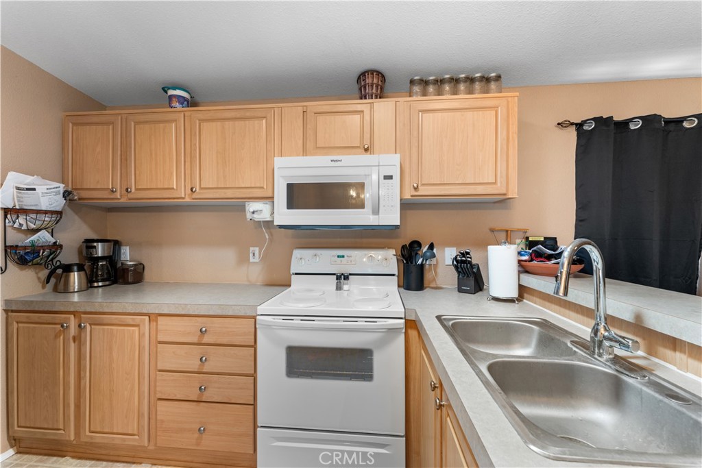 5900 Colorado River Road, Unit 18 Blythe, CA 92225 - Photo 14 of 58 a kitchen with granite countertop a sink dishwasher a stove and cabinets with wooden floor
