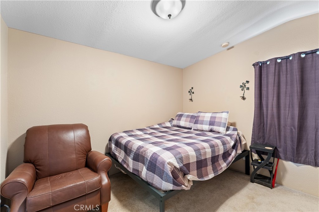 5900 Colorado River Road, Unit 18 Blythe, CA 92225 - Photo 19 of 58 a bedroom with bed and a chair