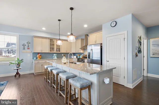 a living room with furniture a rug and kitchen view