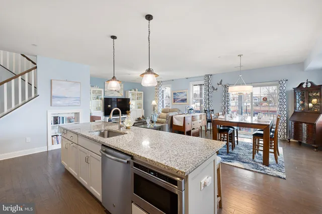 a kitchen with stainless steel appliances kitchen island granite countertop a stove a sink a refrigerator and a wooden cabinets