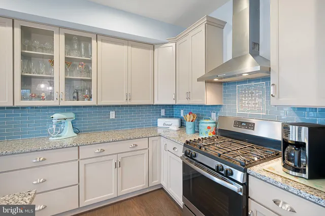 a large kitchen with sink cabinets and wooden floor
