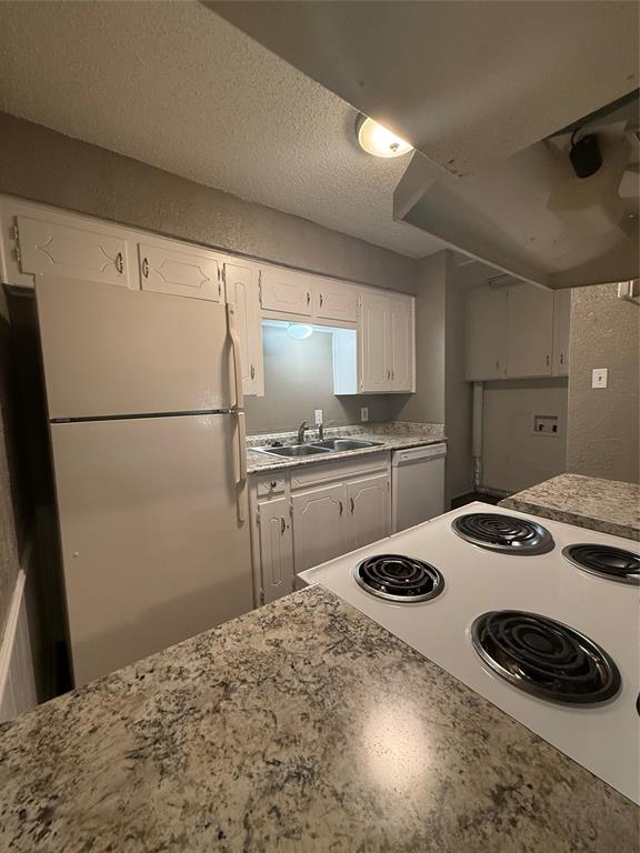 708 East Pecan Street, Unit 712 Hurst, TX 76053 - Photo 7 of 15 Kitchen featuring white cabinetry, a double basin stainless steel sink, a white electric range, and light-toned countertops