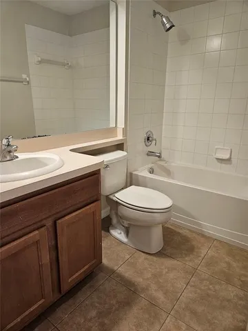 a bathroom with a granite countertop toilet a sink and a bathtub