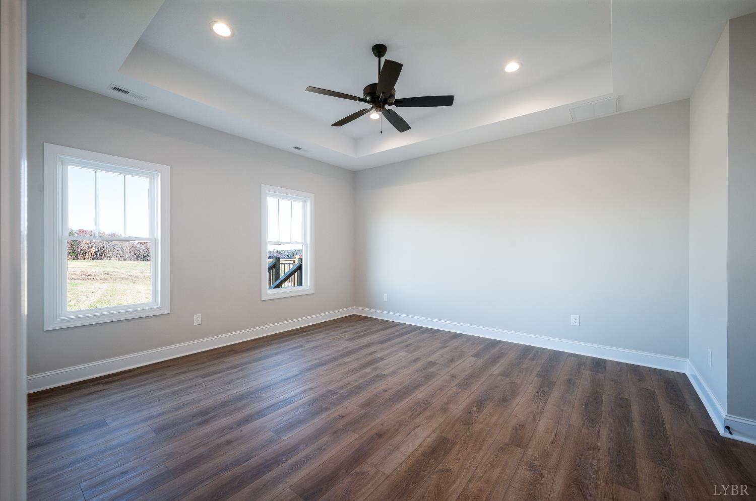 10402 Leesville Road Lynch Station, VA 24571 - Photo 26 of 45 an empty room with wooden floor ceiling fan and windows