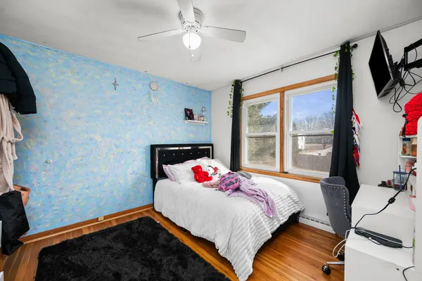 a bedroom with a bed a flat screen tv and a window