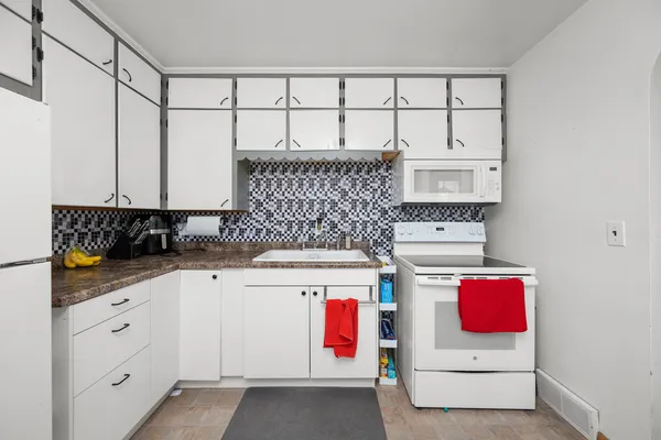 a utility room with cabinets washer and dryer