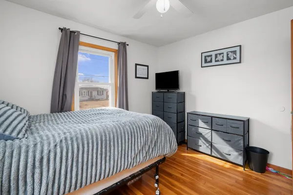 a bedroom with a bed and a flat tv screen on dresser