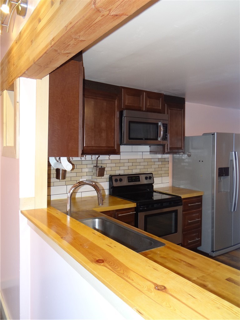 1306 Riverside Avenue Twisp, WA 98856 - Photo 11 of 22 a kitchen with granite countertop a stove and a sink