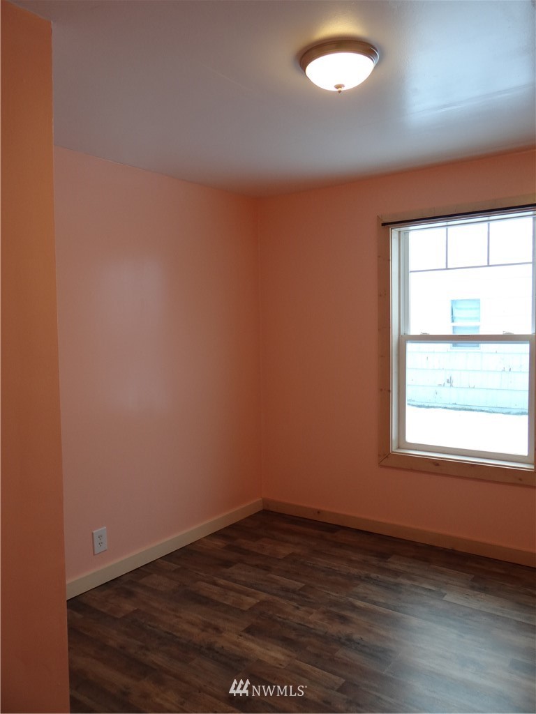 1306 Riverside Avenue Twisp, WA 98856 - Photo 13 of 22 an empty room with wooden floor and windows