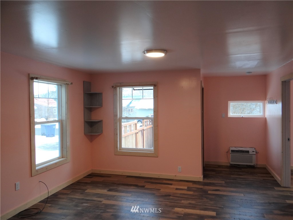 1306 Riverside Avenue Twisp, WA 98856 - Photo 3 of 22 an empty room with wooden floor and windows