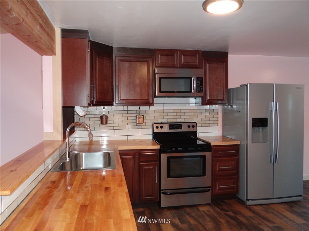1306 Riverside Avenue Twisp, WA 98856 - Photo 9 of 22 a kitchen with stainless steel appliances wooden cabinets and a stove top oven