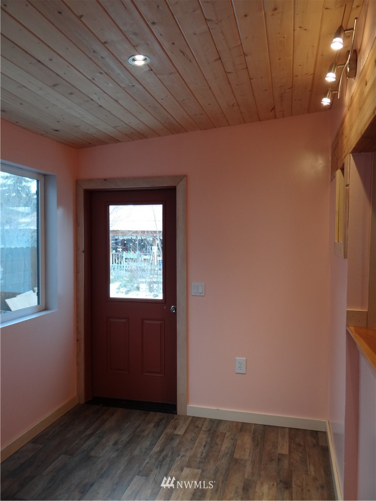 1306 Riverside Avenue Twisp, WA 98856 - Photo 10 of 22 an empty room with wooden floor and windows