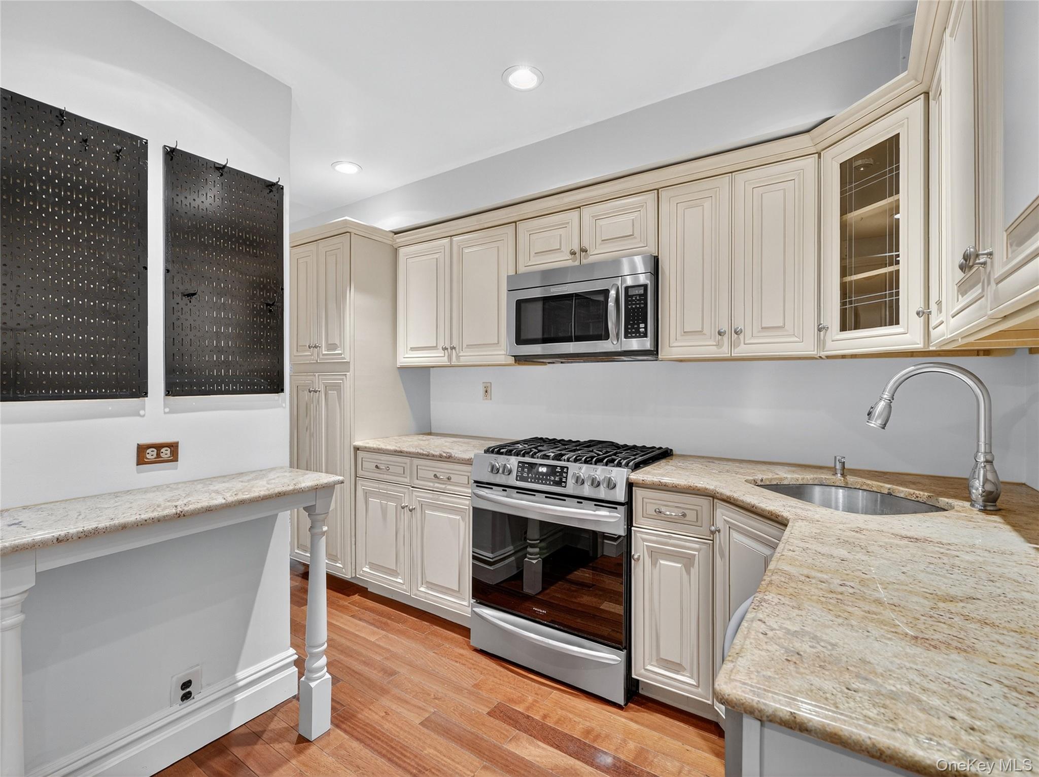 1 Rivermere, Unit I Bronxville, NY 10708 - Photo 5 of 20 a kitchen with stainless steel appliances granite countertop white cabinets stove a sink and dishwasher