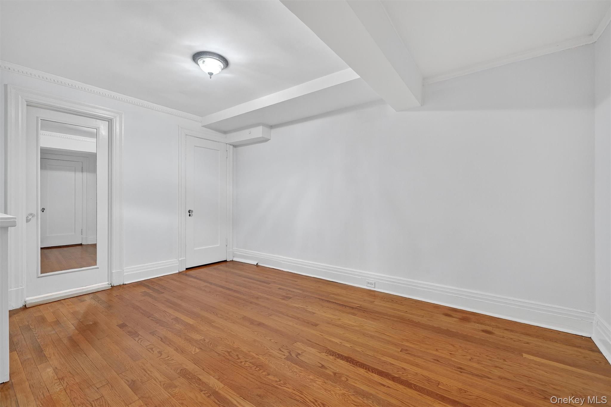 1 Rivermere, Unit I Bronxville, NY 10708 - Photo 9 of 20 an empty room with wooden floor and windows