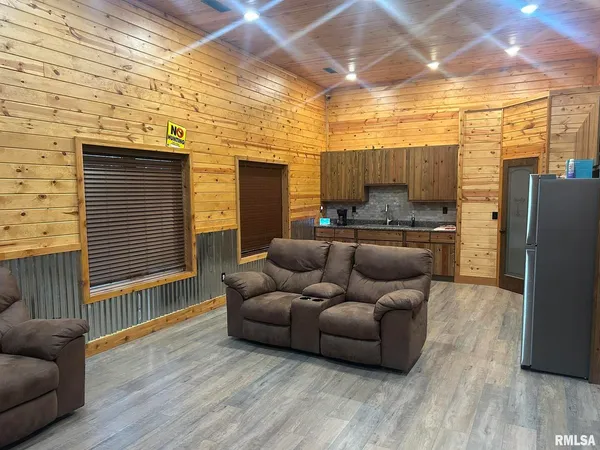 a living room with furniture and a refrigerator