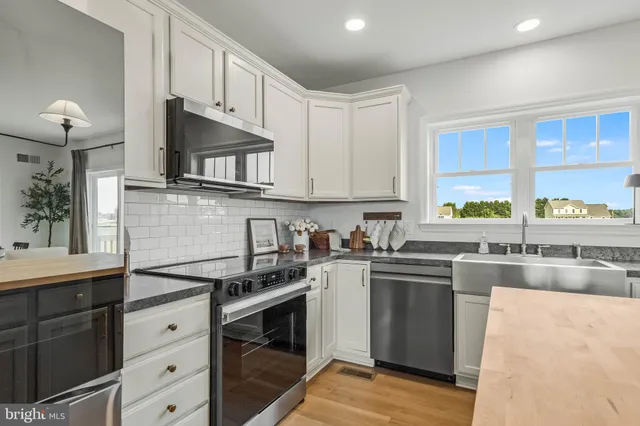 a kitchen with stainless steel appliances a stove sink and cabinets