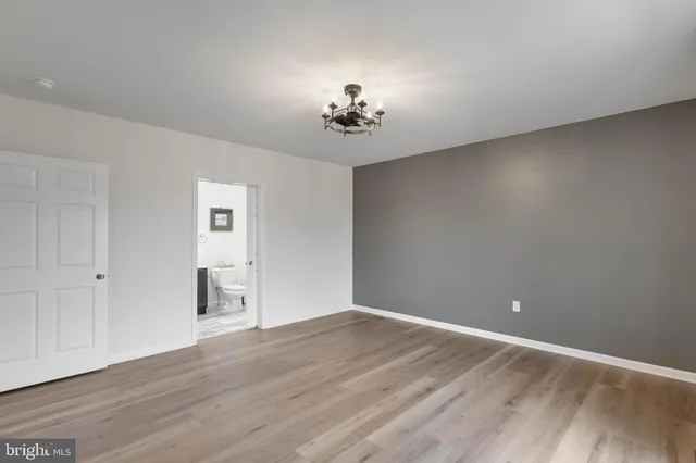 a view of a livingroom with wooden floor and a ceiling fan