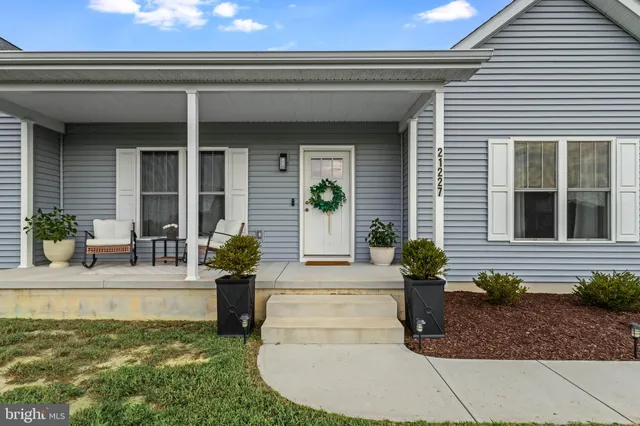 a view of a house with potted plants and a fountain