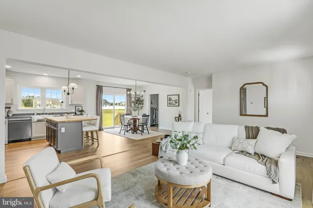 a living room with furniture and view of kitchen