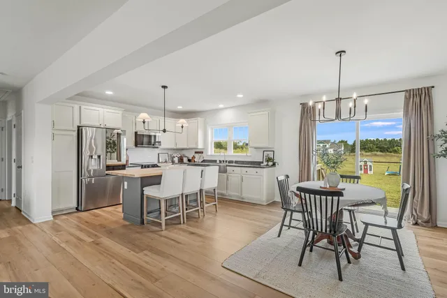 a dining room with furniture a chandelier and wooden floor