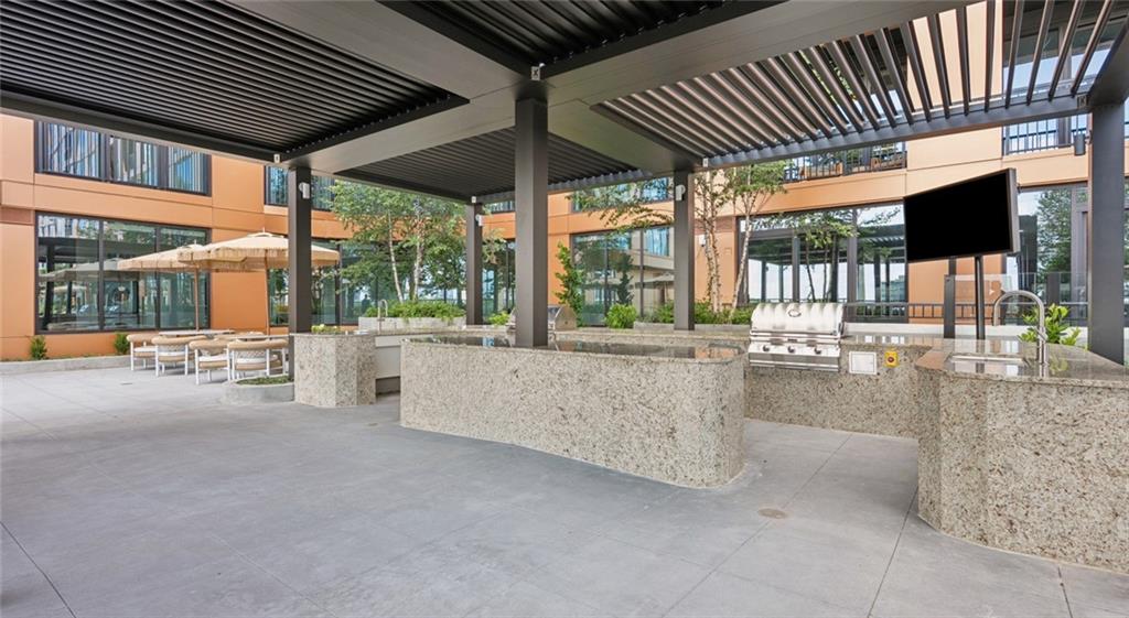 660 11th Street Northwest, Unit 503 Atlanta, GA 30318 - Photo 28 of 45 a view of a patio with a table and chairs under an umbrella with wooden fence