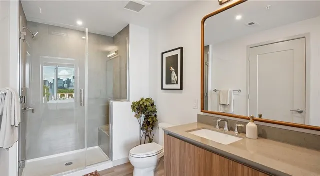 a bathroom with a granite countertop sink toilet and shower
