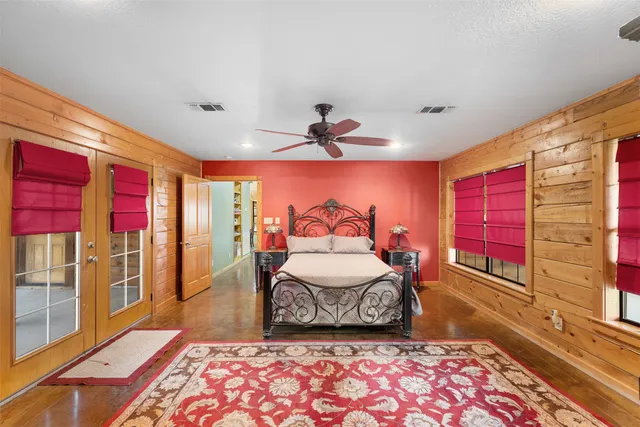 a spacious bedroom with a bed and wooden floor