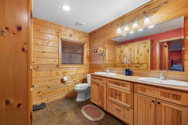 a bathroom with a granite countertop toilet sink and mirror