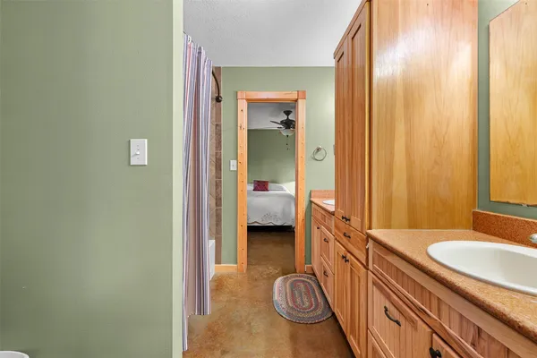 a en suite bathroom with a granite countertop sink and a mirror