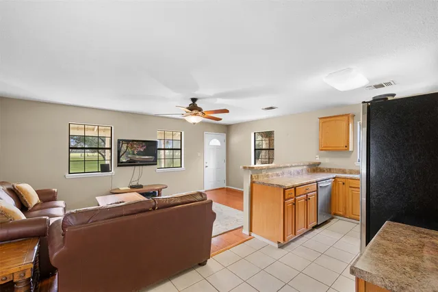 a living room with stainless steel appliances kitchen island granite countertop furniture and a kitchen view