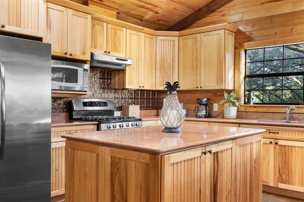a kitchen with stainless steel appliances granite countertop a sink a stove and cabinets