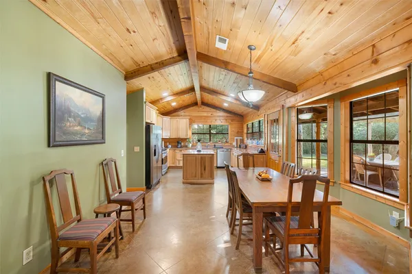 a dining room with furniture a floor to ceiling window and wooden floor