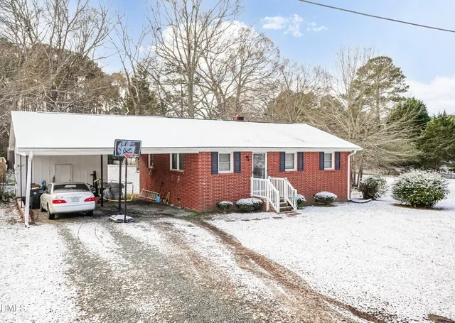 a view of a house with a yard covered in snow