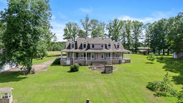 a view of a house with a big yard and large trees