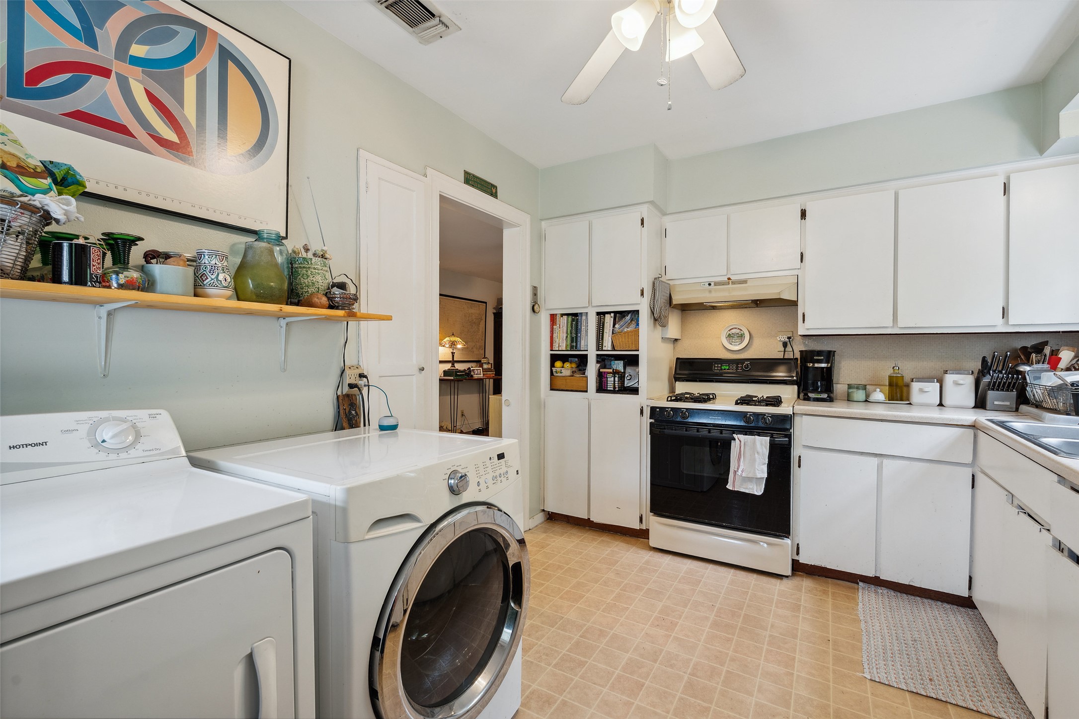 Kitchen with gas stove, storage, and washer/dryer area