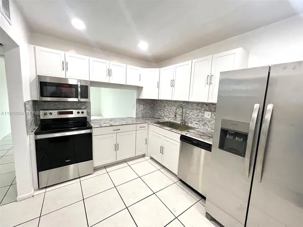 a kitchen with stainless steel appliances cabinets and a counter top space