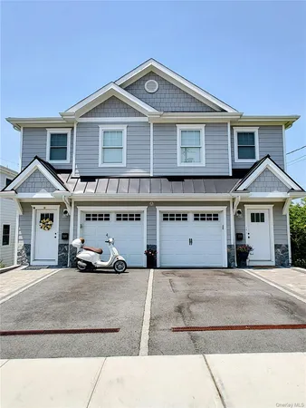 a view of a white house with a large windows and a yard