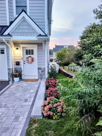 a front view of a house with a yard and potted plants